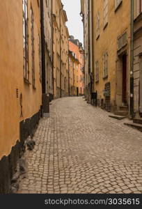 Narrow cobblestone street in Gamla Stan, Stockholm. Narrow street between homes in the old town of Gamla Stan in Stockholm, Sweden. Narrow cobblestone street in Gamla Stan, Stockholm