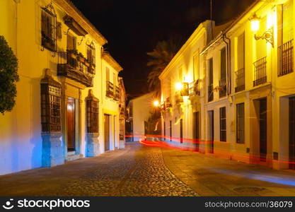 Narrow dark alley in the old town at night illuminated in Ronda, Andalusia, Spain