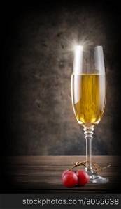 Narrow glass of a white wine on wooden table. Narrow glass of a white wine