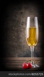 Narrow glass of white wine on wooden table. Narrow glass of white wine