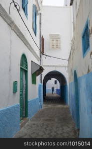 Narrow old street and gate in the medina of Asilah, Morocco