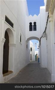 Narrow old street and gate in the medina of Asilah, Morocco