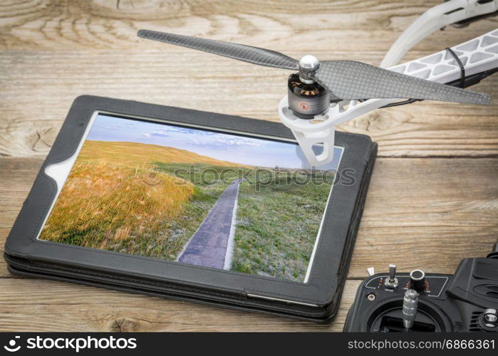 Narrow, one lane road in Nebraska Sandhills, reviewing aerial image on a digital tablet
