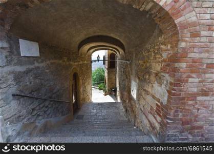 Narrow passage between old houses in Italy. Street with archway in the medieval italian town.