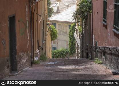 Narrow street between old, unkempt buildings near the Spianata di Castelletto, in Genoa city, Italy.