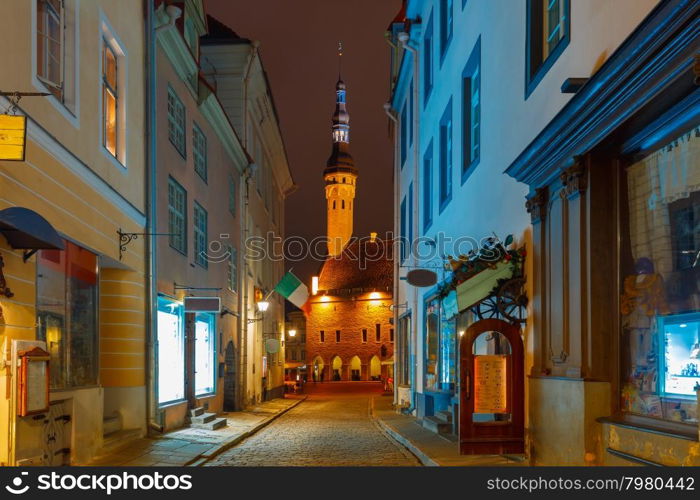 Narrow street illuminated of Old Town at night, City Hall on the background, Tallinn, Estonia