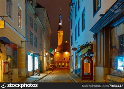 Narrow street illuminated of Old Town at night, City Hall on the background, Tallinn, Estonia
