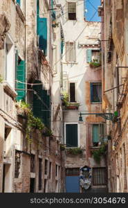 Narrow street in old town in Venice, Italy. Old buildings of mediveval times with ancient architecture.. Venetian buildings in Italy