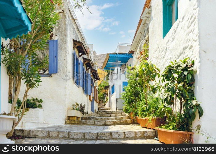 Narrow street in old town of Marmaris, Turkey . Beautiful scenic old ancient white houses with flowers. Popular tourist vacation destination. Narrow street in old town of Marmaris, Turkey . Beautiful scenic old ancient white houses with flowers.