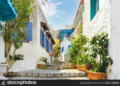 Narrow street in old town of Marmaris, Turkey . Beautiful scenic old ancient white houses with flowers. Popular tourist vacation destination. Narrow street in old town of Marmaris, Turkey . Beautiful scenic old ancient white houses with flowers.