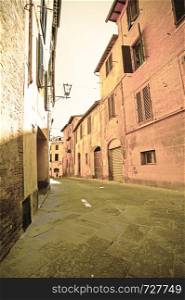 Narrow street in the medieval city of Siena in Tuscany