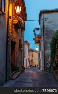 Narrow street in the old town at night in Italy