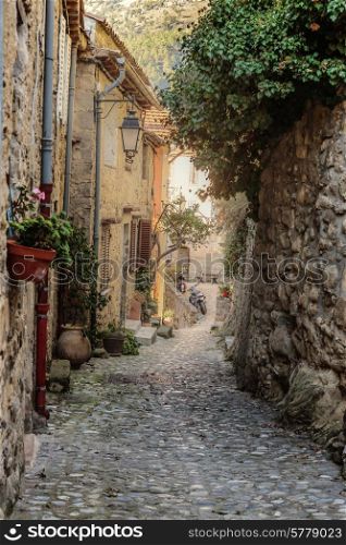 Narrow street with flowers in the old town Coaraze in France