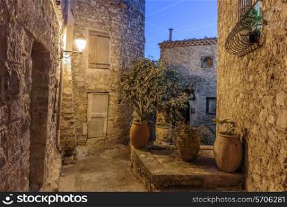 Narrow street with flowers in the old village Peille in France. Night view