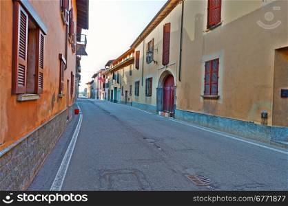 Narrow Street with Old Buildings in Italian City in Piedmont