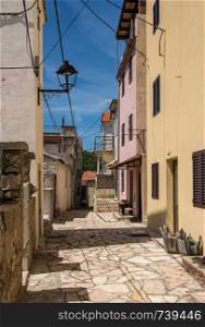 Narrow street with rustic houses and homes in the coastal town of Novigrad in Croatia. Rustic homes in Croatian town of Novigrad in Istria County