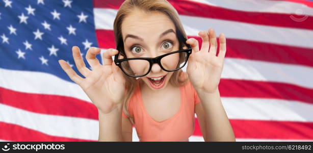 national, education and people concept - happy surprised young woman or teenage girl eyeglasses over american flag background