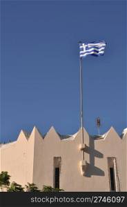 national flag of Greece on Kos town building (blue sky background)