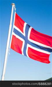 National flag of Norway waving on a blue sky