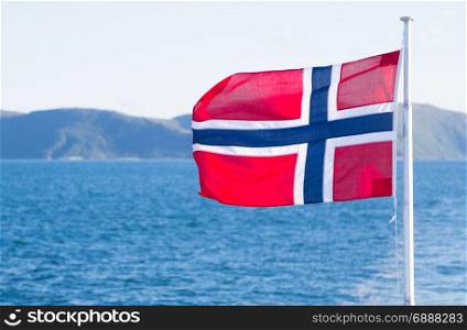 National flag of Norway waving on a blue sky