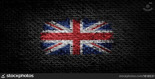 National flag of the United Kingdom on dark fabric.. National flag of the United Kingdom on dark fabric