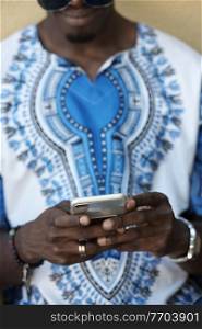 Native Sudan black african man using smart phone and wearing traditional clothes
