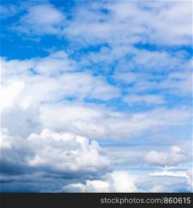 natural background - dense white and gray clouds in blue sky on summer day