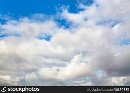 natural background - low gray and white autumn clouds in blue sky on windy day