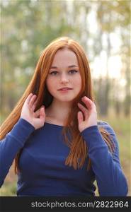 Natural beautiful red-haired girl head and shoulders shot outdoor