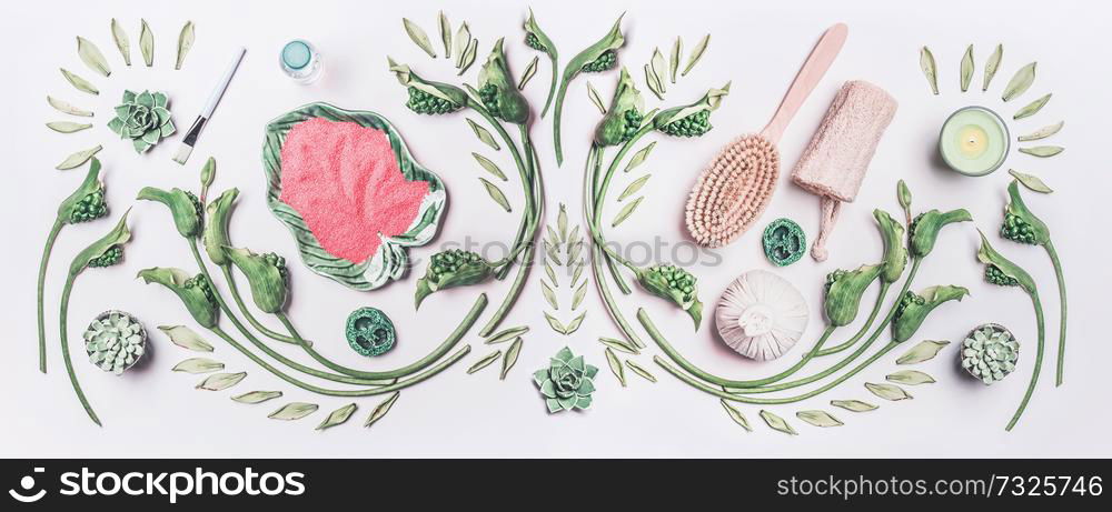 Natural body care, spa and cosmetic concept. Composing with green tropical leaves and flowers, bowls , sea salt and dry massage equipment on white table background, top view, flat lay.