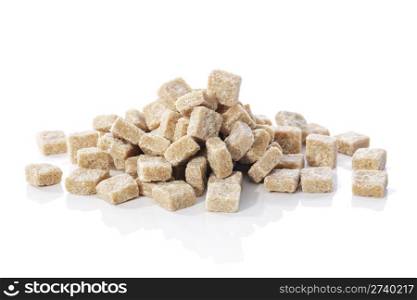 Natural brown sugar cubes on white reflecting background