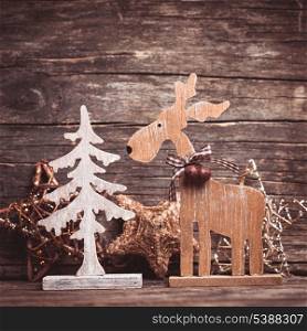 Natural christmas decor - deer and fir tree over wooden background