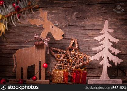 Natural christmas decor - deer and fir tree over wooden background