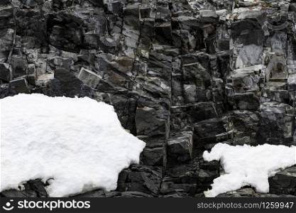 Natural climbing wall through black rock with steps vertically upwards