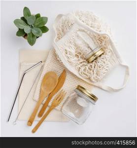 Natural color eco bags, reusable metal and bamboo straws, glass jars, wooden knifes and forks, zero waste cleaning and beauty products, flat lay. Zero waste, Recycling, Sustainable lifestyle concept, flat lay