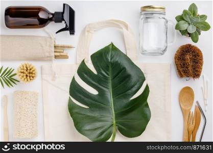 Natural color eco bags, reusable metal and bamboo straws, glass jars, wooden knifes and forks, zero waste cleaning and beauty products, flat lay