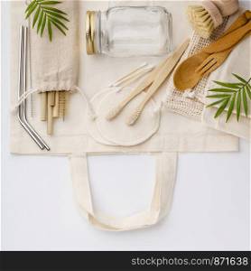 Natural color eco bags, reusable metal and bamboo straws, glass jars, wooden knifes and forks, zero waste cleaning and beauty products, flat lay. Zero waste, Recycling, Sustainable lifestyle concept, flat lay