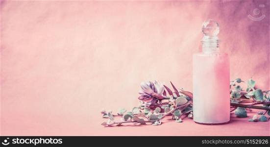 Natural cosmetic product in bottle with herbs and flowers on pink background, front view, banner, place for text. Healthy skin or body care or beauty , wellness treatments concept