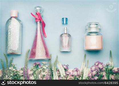 Natural cosmetic products. Jars and bottles with tonic , mist, perfume,cream ,tonic and micellar water on herbal leaves and wild flowers background, copy space for your text or branding , top view