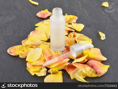 Natural cosmetics and rose petals on shale