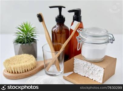 natural cosmetics, beauty and eco living concept - wooden toothbrushes, cotton swabs in paper box with soda, brush and soap on white background. wooden toothbrush, cotton pads and swabs in box
