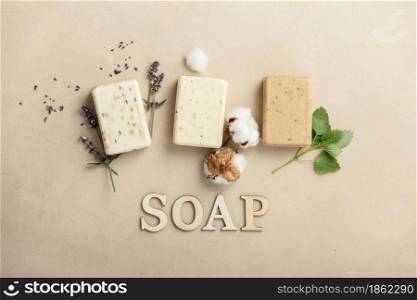 Natural DIY soap bars - lavender, cotton, patchouli - ingredients and wooden letters on natural stone background, top view. Handmade organic soap concept