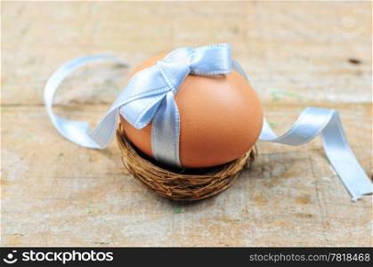 Natural easter egg with light blue ribbon in nest