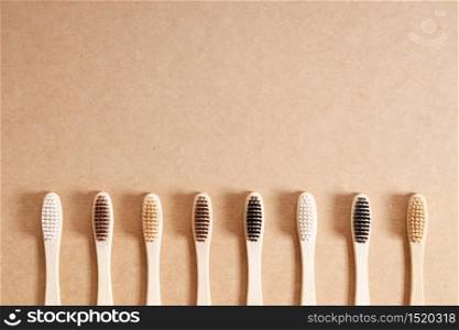 natural eco friendly toothbrush with wooden bamboo handle on brown background.