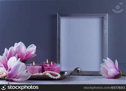 Natural eco home decor. Gray room interior decor with magnolia flowers, burning hand-made candle and poster mock up
