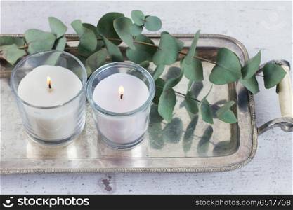 Natural eco home decor. Natural eco home decor with green leaves and burning candles on table