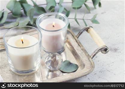 Natural eco home decor. Natural eco home decor with green leaves and burning candles on tray