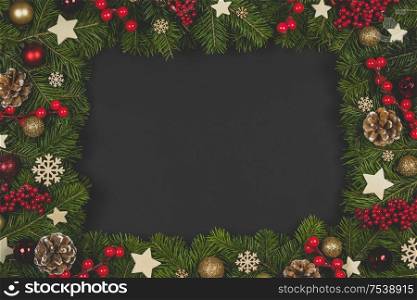Natural fir Christmas tree border frame with decor on black, copy space for text. Fir tree branch frame on white