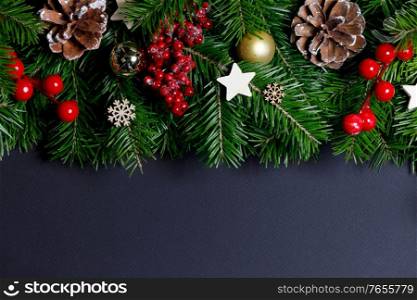Natural fir Christmas tree border frame with decor on black, copy space for text. Christmas tree with decor on black