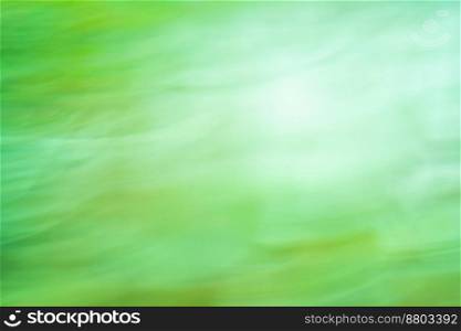 Natural green blurry defocused dynamic abstract background. Fresh spring green high speed motion blurred background.. Green fast speedy motion. Green slow shutter speed with motion blur effect.